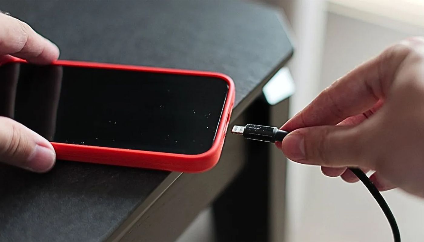 Telefon conectat la încărcător peste noapte, cu bateria la 100%