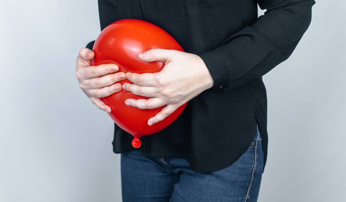 Femeie cu mâinile pe abdomen, simțind balonare