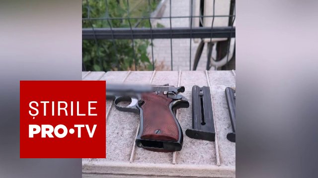 Polițist examinând un pistol și muniție găsite într-o mașină