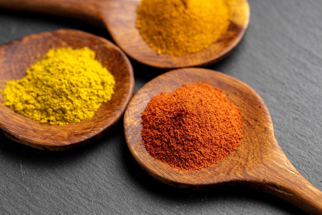 Turmeric pudră și rădăcini proaspete pe o masă de lemn
