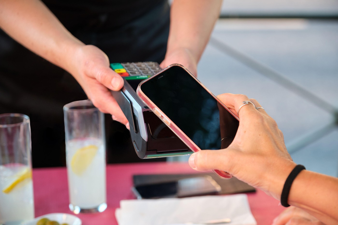 Ospătar cu un card POS și bancnote, ilustrând preferința pentru bacșiș cash vs. card