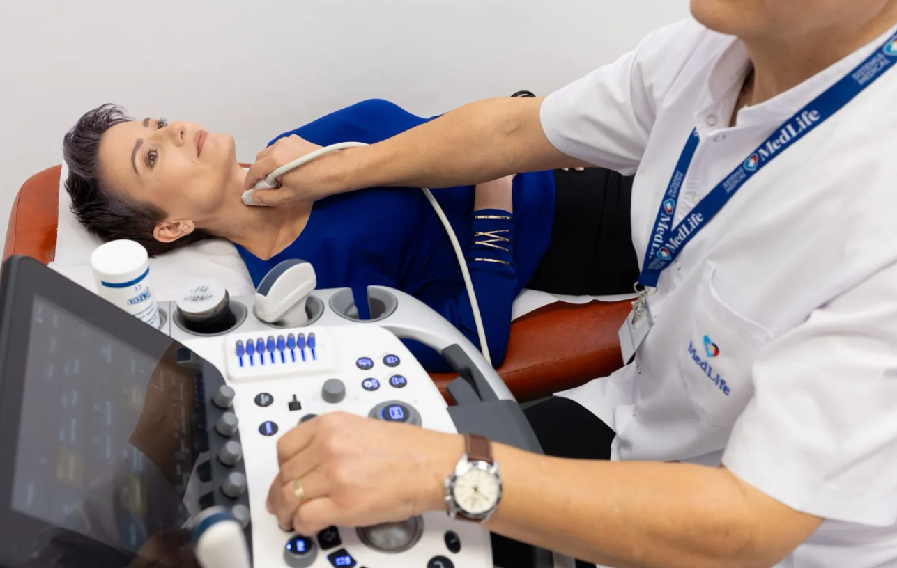 Medic endocrinolog consultând o pacientă cu probleme tiroidiene