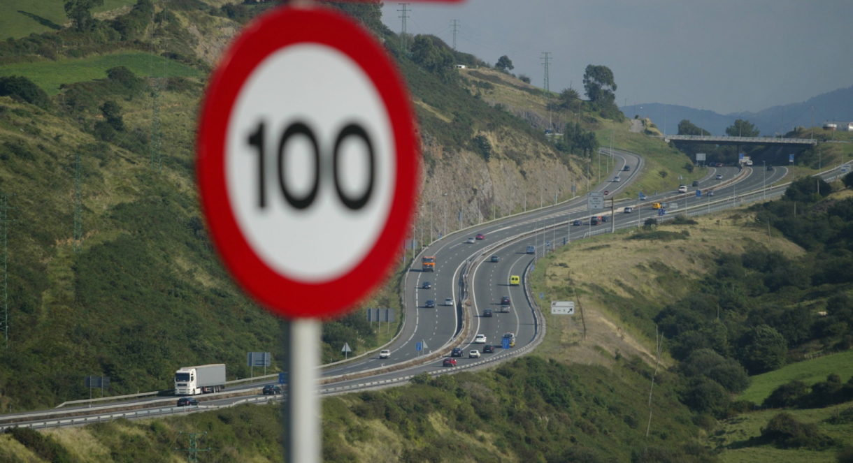 Mașină pe autostradă cu indicatoare de viteză în fundal