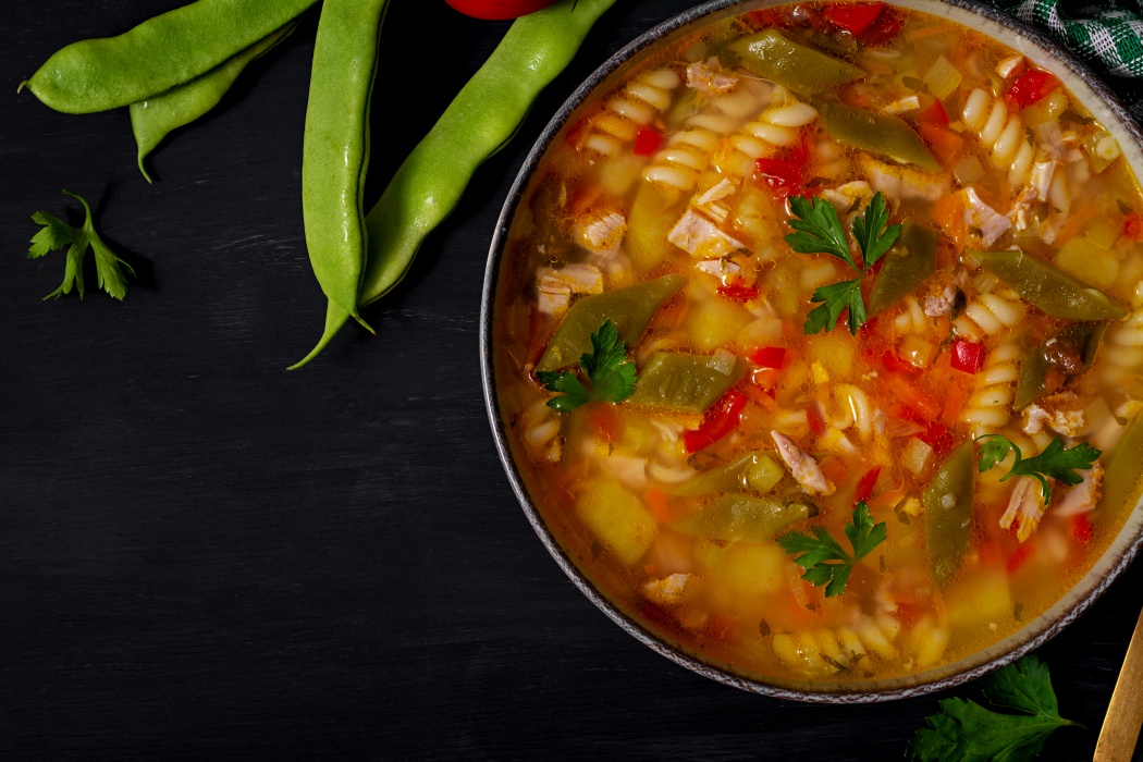 Minestra italiană servită cu parmezan și pâine rustică