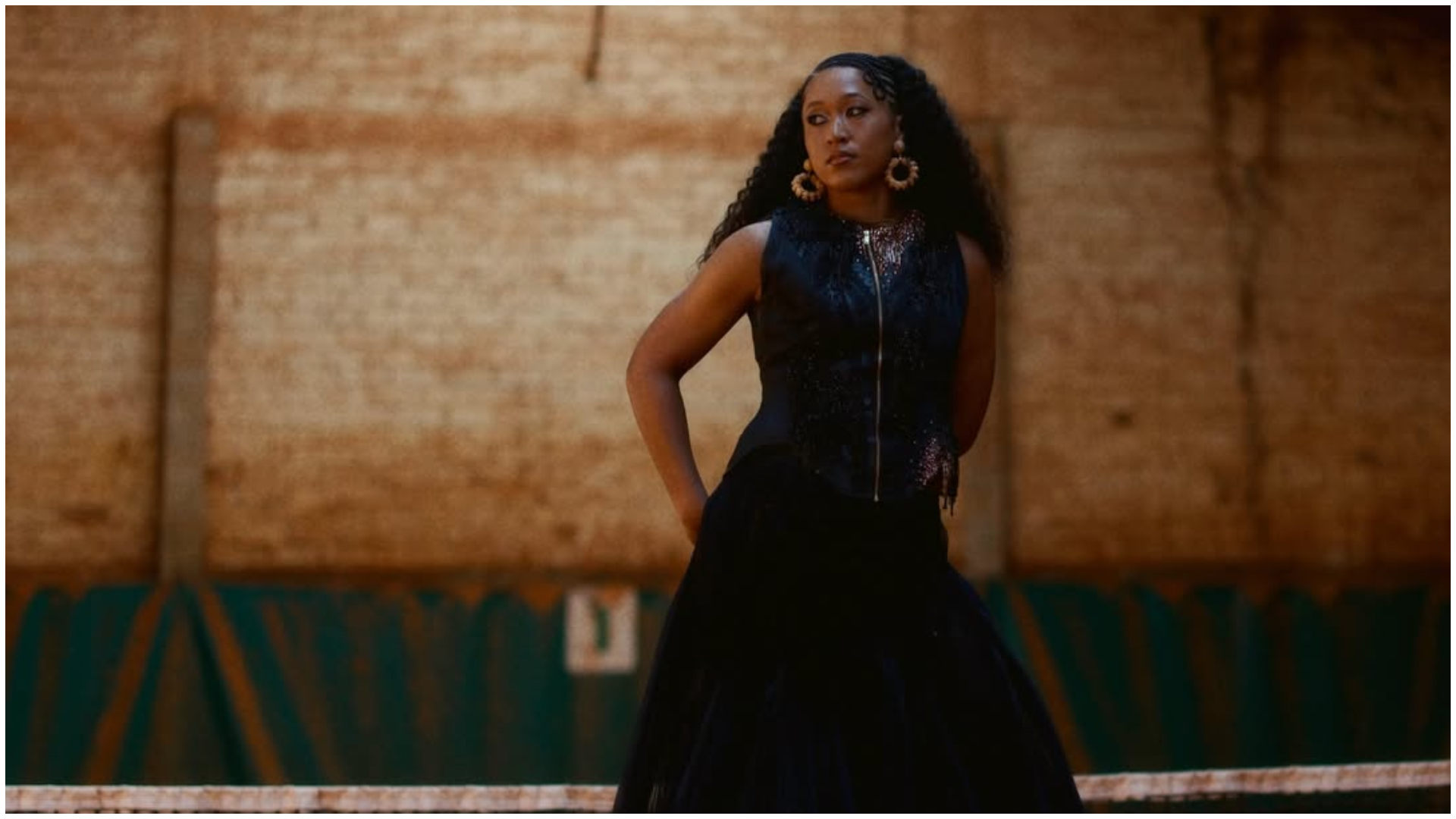 Naomi Osaka pe terenul de la Roland Garros, îmbrăcată într-o jachetă cu paiete aurii și fustă din tul
