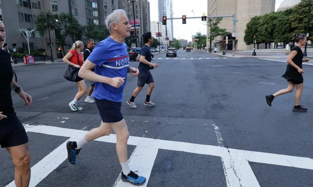 Premierul Norvegiei Jonas Gahr Stoere făcând jogging la Boston, însoțit de jurnaliști și gărzi de corp