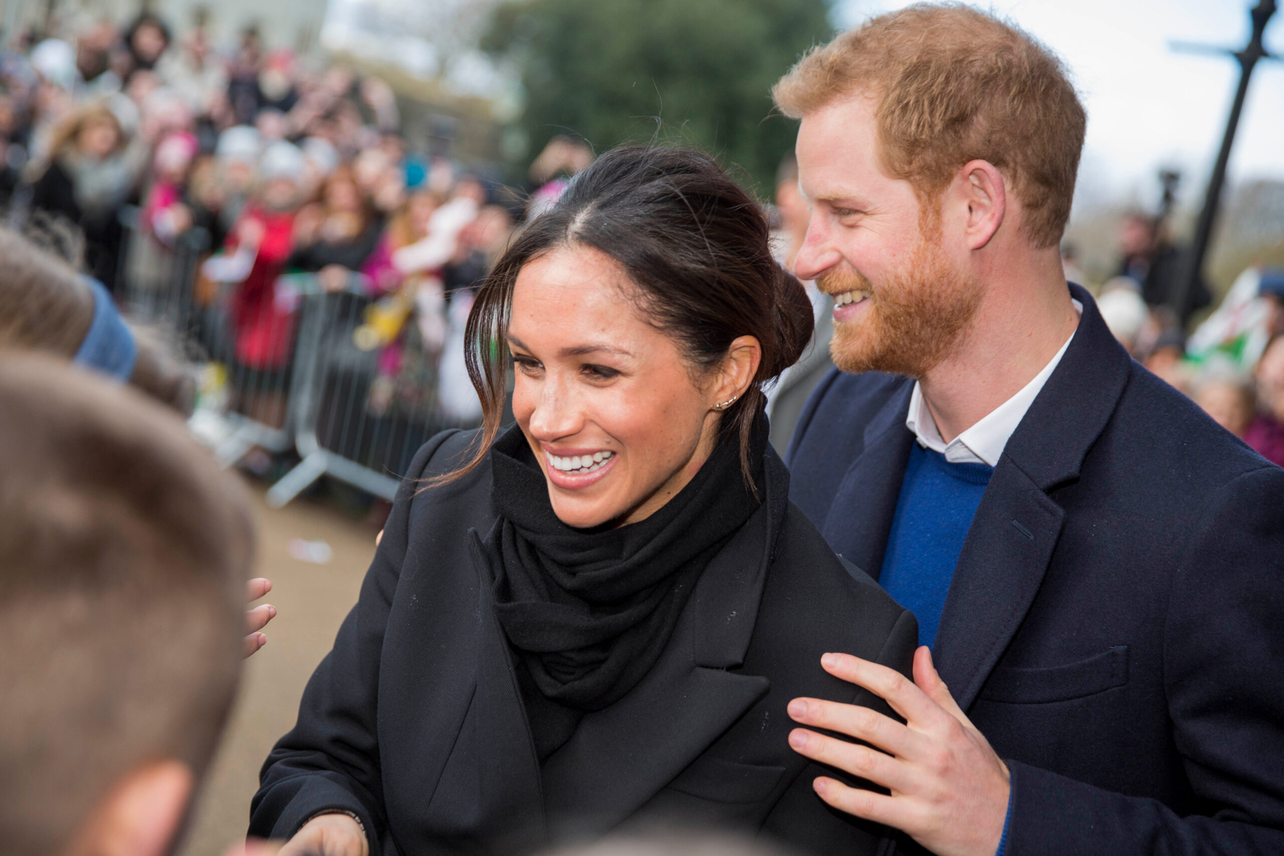 Prințul Harry și Meghan Markle zâmbind la un eveniment public