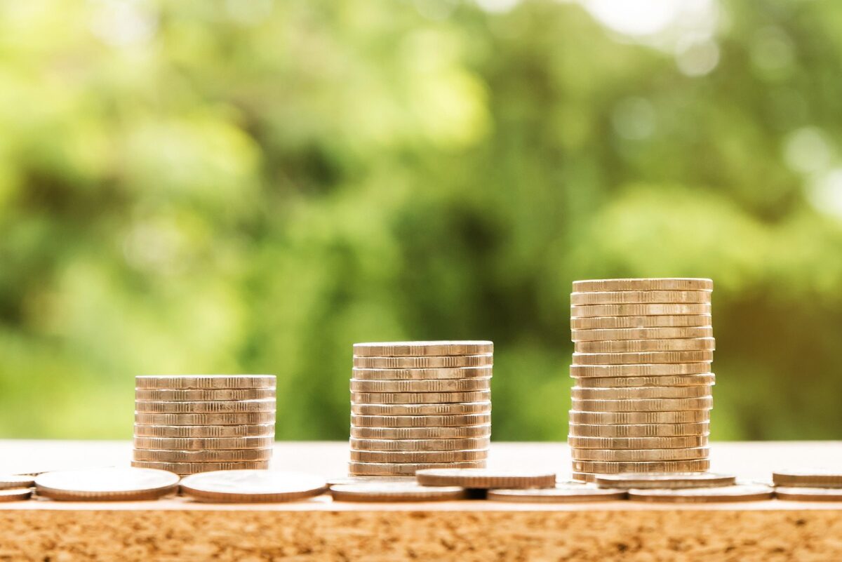 Monede și grafice financiare, simbolizând economisirea pentru pensie