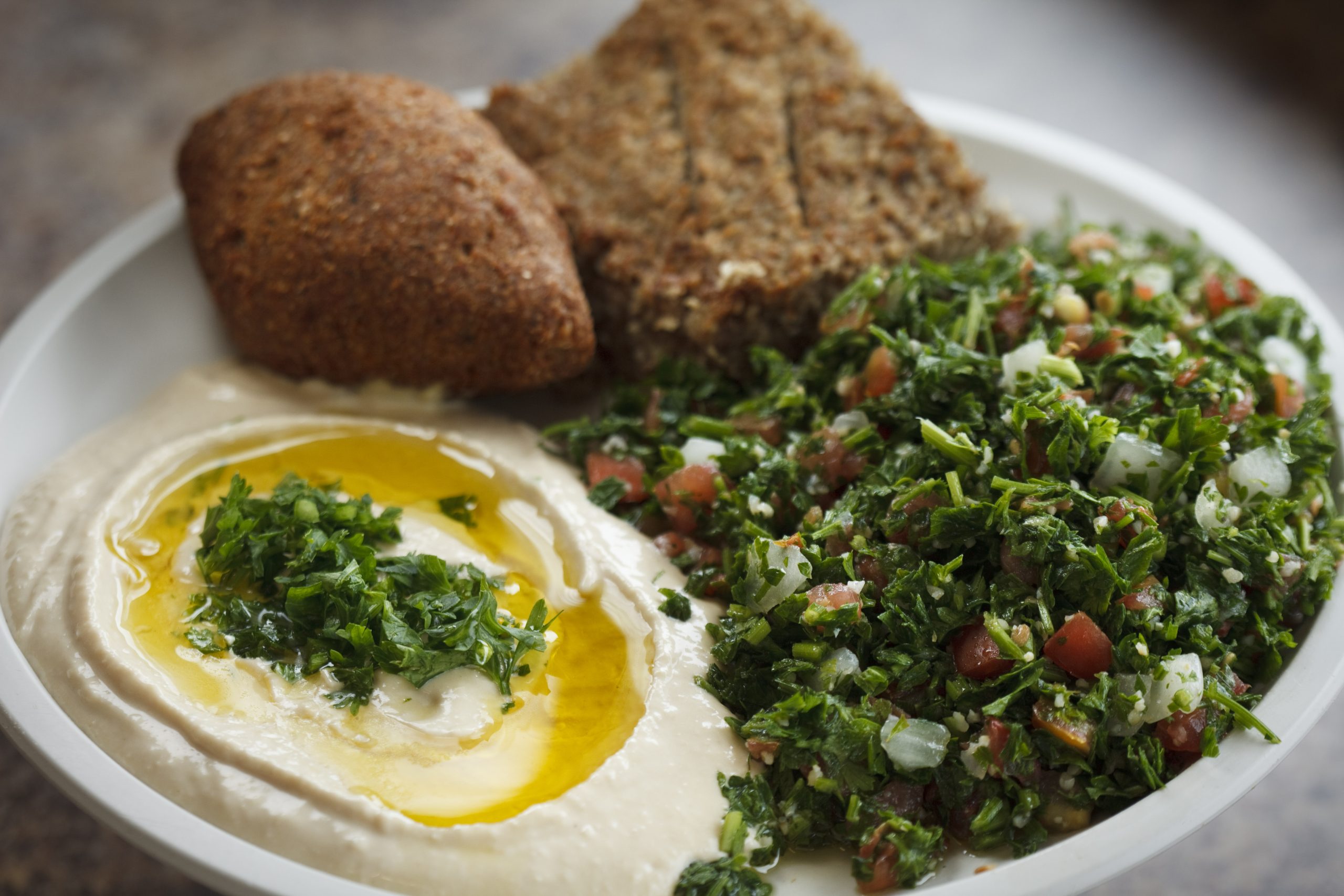 Salată tabbouleh într-un bol, cu verdețuri și roșii
