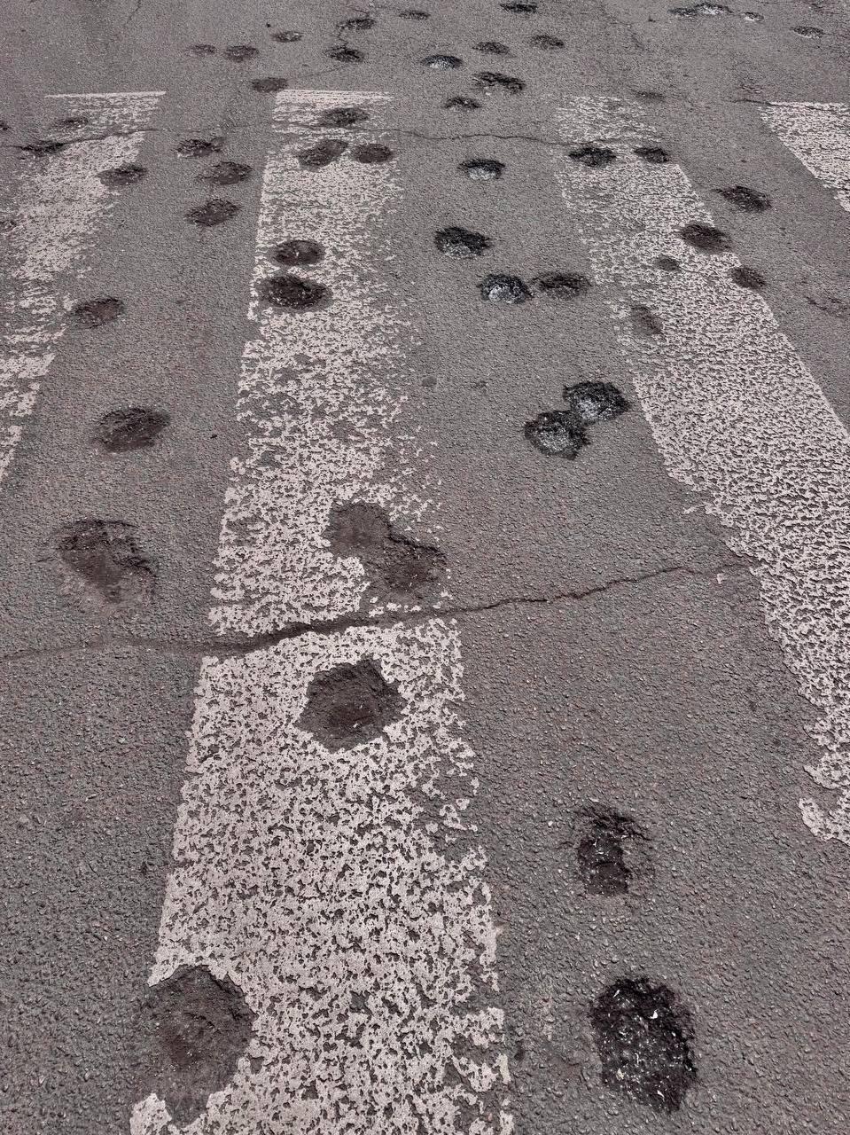 Fotografie cu asfalt deteriorat de muniție cu dispersie la Dnipro
