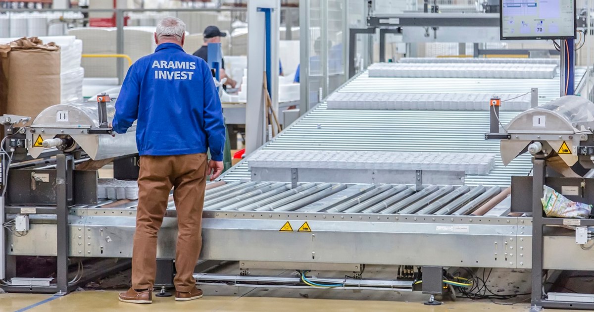 Angajați Aramis Invest discutând în birou