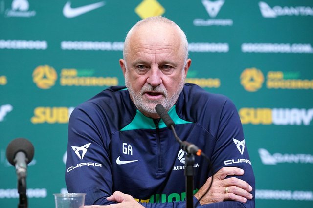 Selecționerul Irakului, Graham Arnold, zâmbind la o conferință de presă