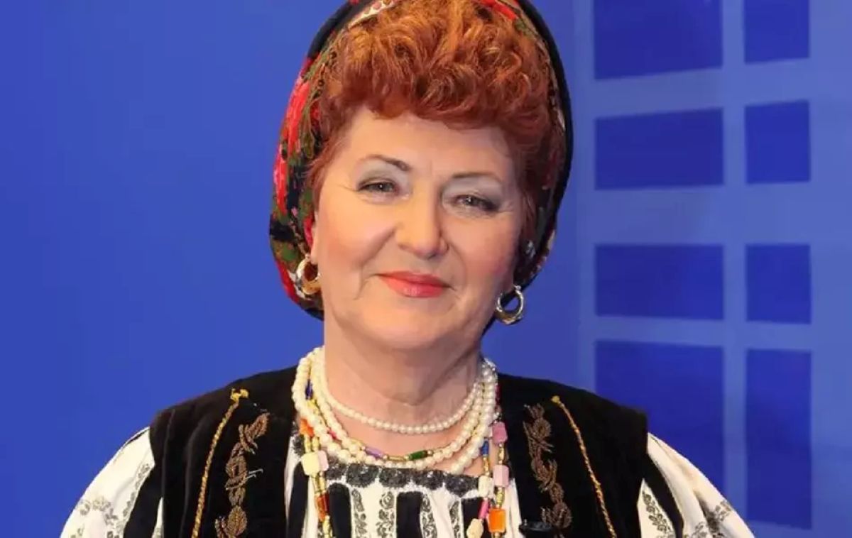 Veta Biriș zâmbește în timp ce poartă o ie românească tradițională