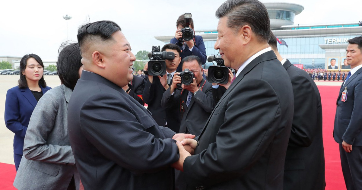 Xi Jinping și Kim Jong Un strângând mâinile