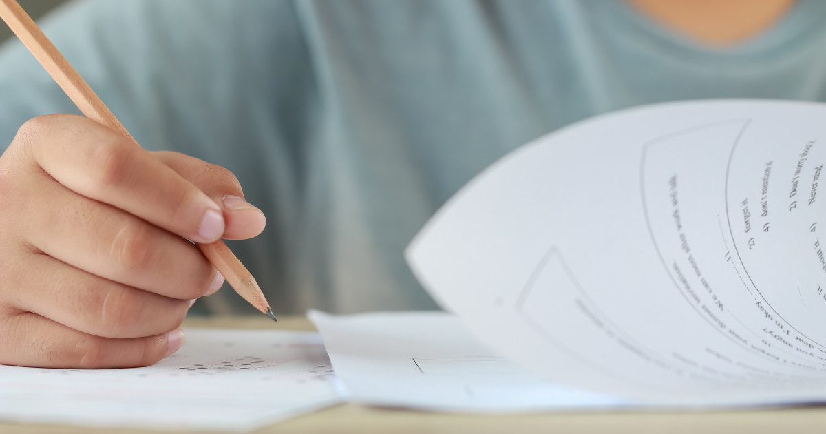 Elevi la bacalaureat consultând lucrările în sala de examen