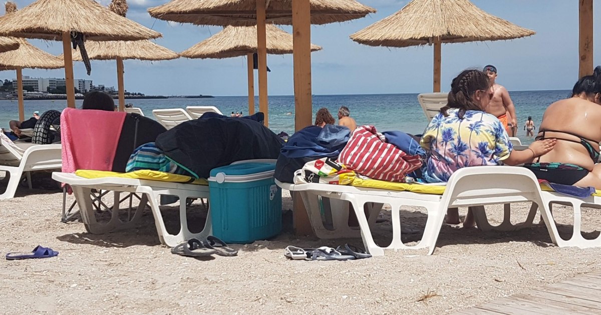 Imagine cu o plajă și hoteluri pe litoral, simbolizând riscul creșterii nivelului mării