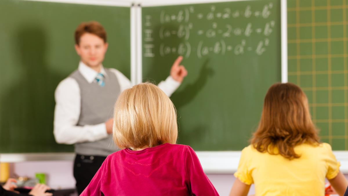 Profesor la tablă în clasă