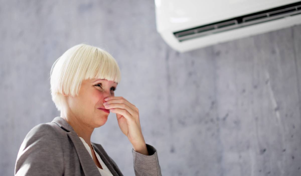 O persoană intrând dintr-un mediu cald într-o încăpere cu aer condiționat, simțind un val de aer rece
