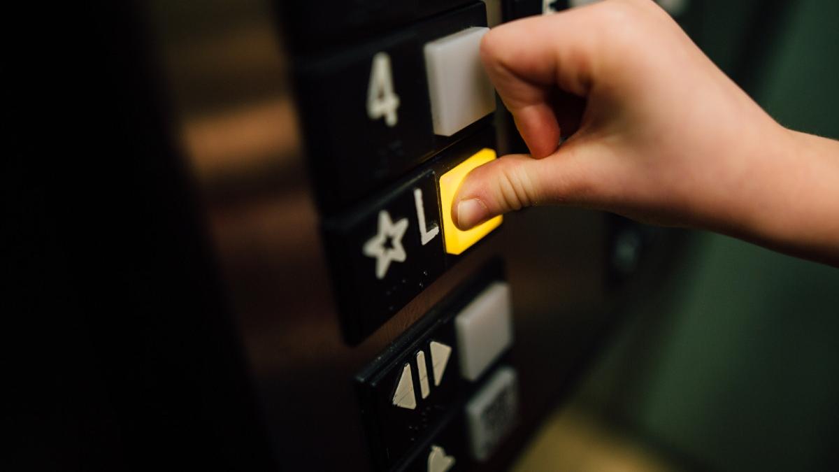 Lift exterior montat la un bloc vechi, cu structură metalică și cabină