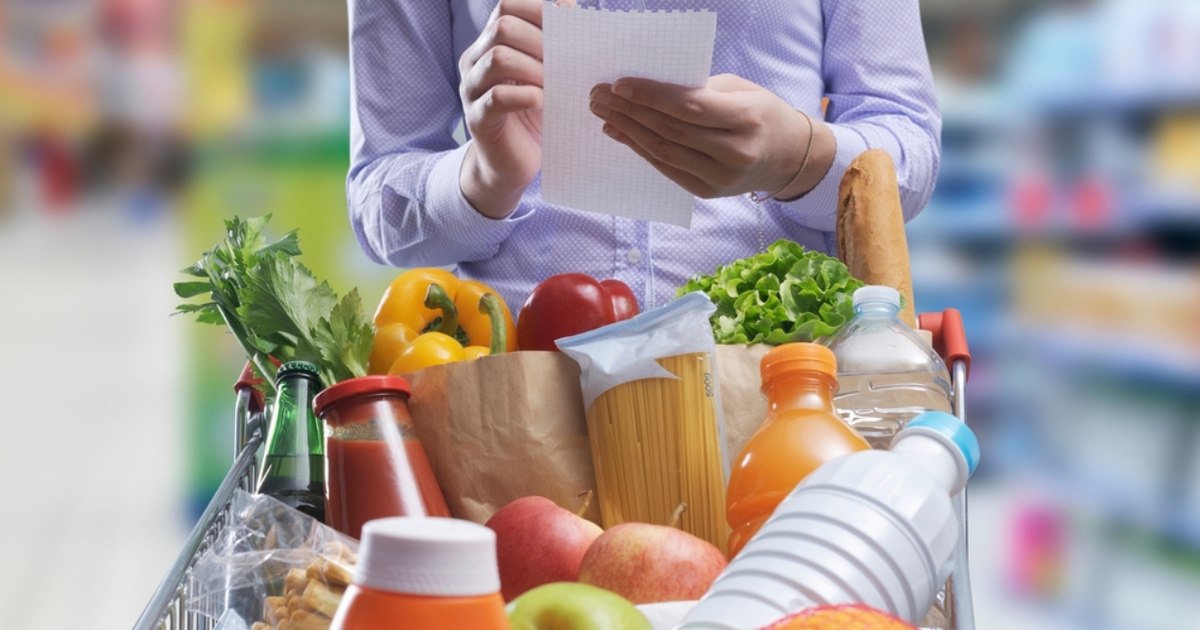 Consumator analizând eticheta unui produs într-un supermarket